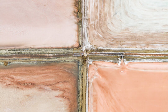 Aerial view of the colorful salt evaporation ponds at Great Salt Lake with geometric patterns and textured mineral deposits in Salt Lake City, Utah, United States.