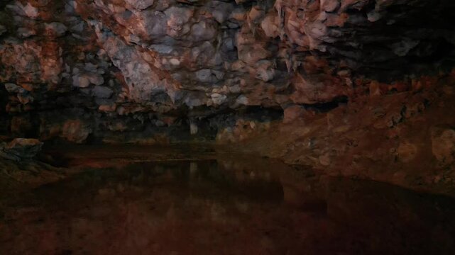 Cave with reflective water surface and rocky formations