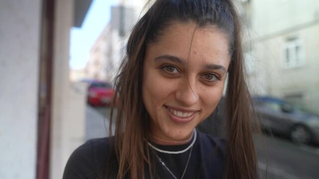 Woman smiling and looking aside at a pavement cafe