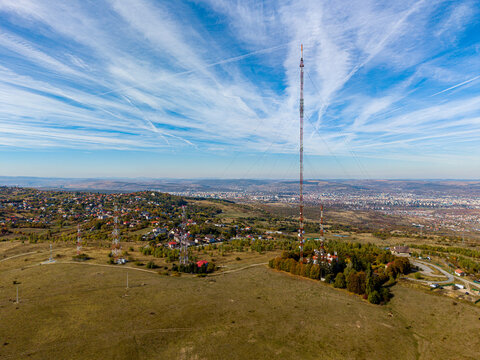 Aerial view of the Feleacu 311A TV tower and surrounding telecommunication masts on a grassy hill overlooking the city of Cluj-Napoca, Judetul Cluj, Romania.