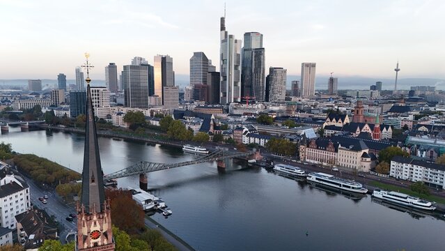 Aerial view of the Frankfurt am Main skyline with the Main river, Eiserner Steg bridge, and a church spire in the foreground, Frankfurt am Main, Hessen, Germany.