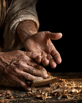 Here are the calloused hands of a carpenter on a black background
