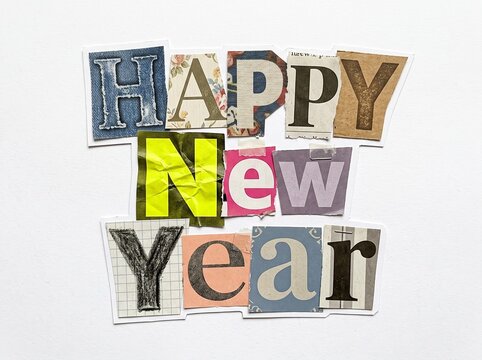 Creative Happy New Year text crafted from diverse paper cutout letters with tape details in a vintage ransom note collage sticker style on a clean white background.