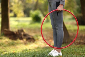 Senior woman with hula hoop in park, closeup. Space for text © New Africa