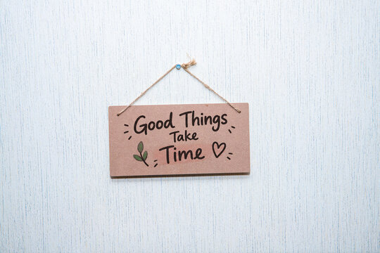 Good Things Take Time Inspirational Quote on Hanging Wooden Sign, Patience and Personal Growth Concept.