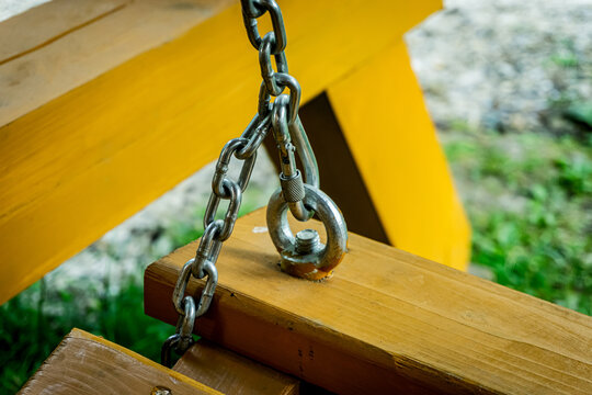 Chain and carabiner on wooden swing