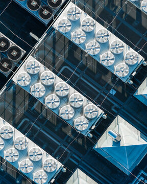 Aerial view of secured data center infrastructure featuring rows of industrial cooling fans and ventilation units on a rooftop in Warsaw, Masovian Voivodeship, Poland.