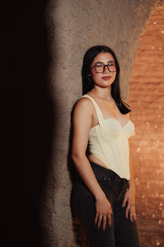 Photoshoot of a beautiful young Latina woman wearing glasses in a bar.