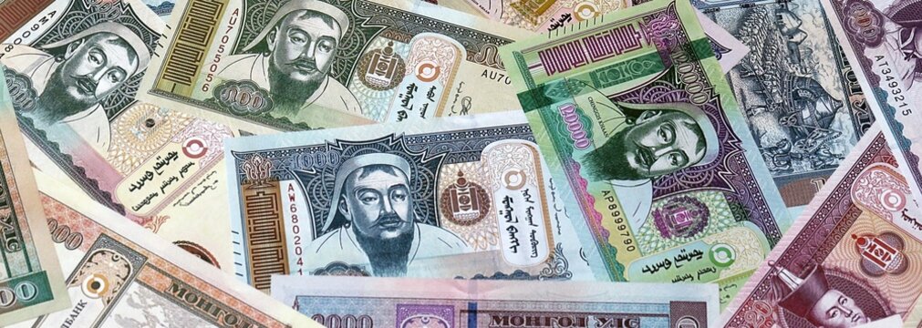 Mongolian tugrik money bills in pile on table. Mongolia MNT currency banknotes background