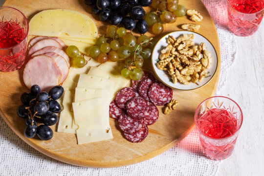 Cheese and Salami Appetizer Board with Grapes, Nuts and Rose Wine