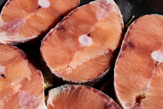 Close up view of pork chops with bone in showing pink orange flesh and marbling, with pork, chop, meat, raw detail, showing bone, bonein, marbling, fat context, with clear visible detail
