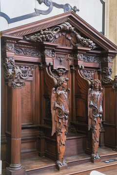 Elaborately carved wooden confessional booth with winged angel statues inside St. Charles Borromeo Church in Antwerp, Belgium.