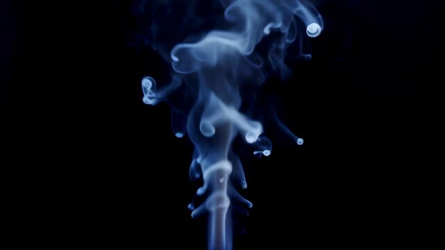 Soft White Tendrils of Steam Rising Against Black Background