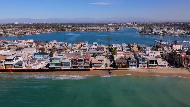 Damaged bulkhead and eroded beach in front of sandbagged, boarded up homes on the Peninsula after Tropical Storm Rachel surge, Alamitos Bay behind. Long Beach, California, USA - October 15, 2026