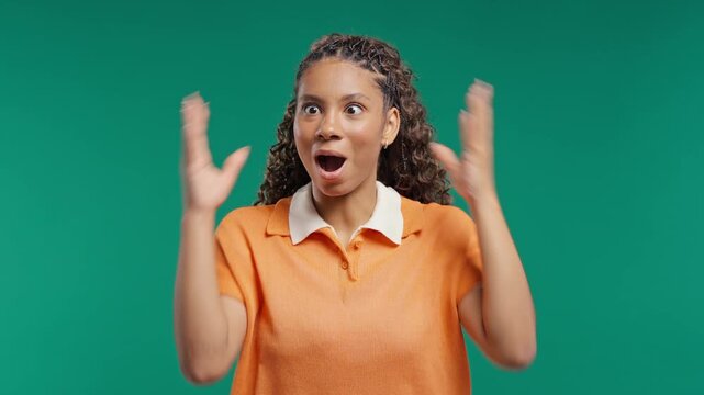 Surprised teenage Girl Making Mind Blown Gesture On green Background.Expresses Wow, incredible news, breakthrough ideas,exciting discoveries