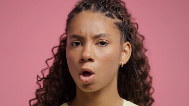 Serious teenage girl disapproving with no head sign, nods head disapprovingly. Denying, Rejecting, Disagree, Portrait of pretty young woman on pink background