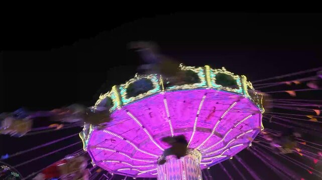 Buntes Kettenkarussell mit Menschen in voller Fahrt auf einem Volksfest