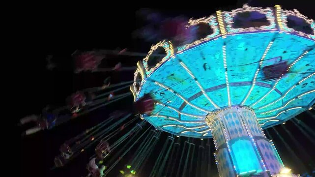 Buntes Kettenkarussell mit Menschen in voller Fahrt auf einem Volksfest