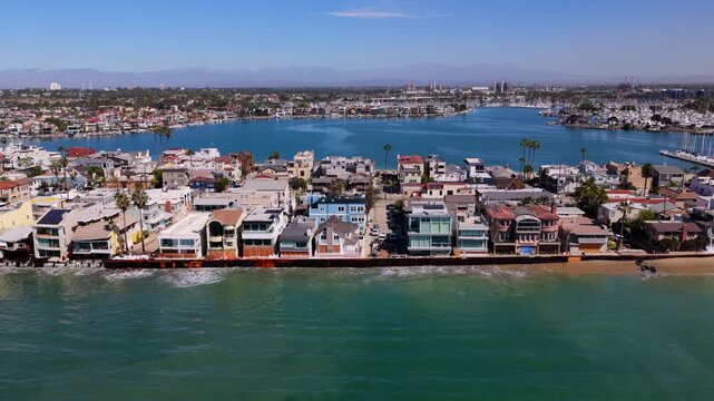 Long Beach, California, USA - October 15, 2026: Flight right to left along boarded up beach homes, patched bulkhead and sandbags on the Peninsula after Tropical Storm Rachel, Alamitos Bay behind.