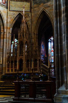 Prague, Czechia - 05 October 2026: View of the ornate Gothic altar and stained glass windows inside St. Vitus Cathedral, featuring intricate stone carvings and religious iconography.