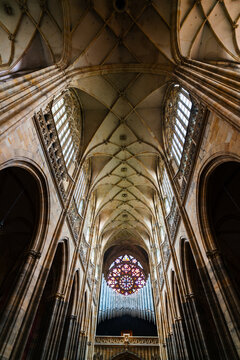 Prague, Czechia - 05 October 2026: View of St. Vitus Cathedral, featuring intricate Gothic rib vaulting, tall stone columns, and a large stained glass rose window in the background.
