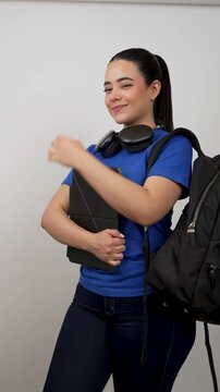 Young latina student holding tablet and backpack posing