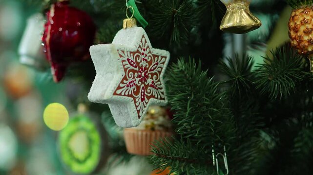 Gingerbread star and pineapple glass ornaments on Christmas tree branch, colorful vintage winter holiday decorations macro video footage for festive xmas greeting card commercial background concept
