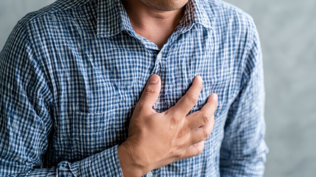hand hold chest with heart attack symptoms, have chest pain caused by heart disease, leak, dilatation, enlarged coronary heart, press on the chest with a painful expression