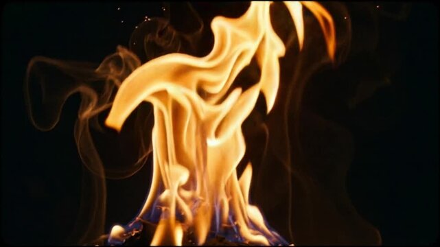 A vibrant orange and yellow flame intensely flickers and dances with captivating motion against a deep dark background, symbolizing primal energy and warmth.