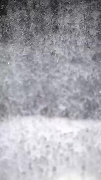 Slow motion close-up of crystal clear water flowing and creating powerful white foam splashing surface