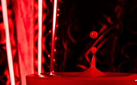 Red blood pouring into glass. Filling red wine into glass make splashing spill droplet blood around as crown. Abstract background, high speed photograph