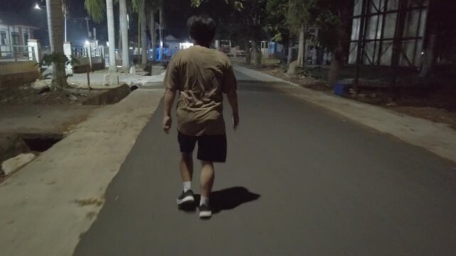 A person brisk walking at night as part of a dedicated fitness routine to lose weight and improve physical health. This outdoor exercise activity highlights determination, calorie burning, weight mana