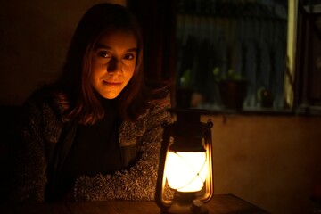 Woman looking at the camera beside a warm glowing lantern in Guatemala © nobito_gt