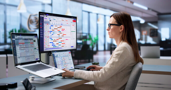 Fashion Designer Inspects Garment Samples While Working On Laptop