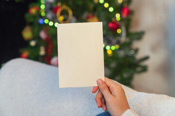 woman hand holding a Christmas greeting card, holiday celebration, festive season. © sitthiphong