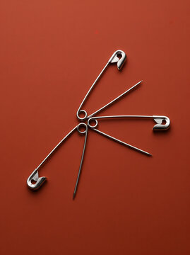 Safety Pins Arranged on a Red Background with Flatlay Composition   
