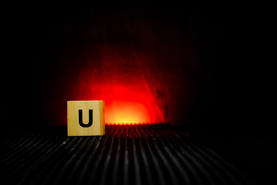 wooden letter tiles arranged on a dark surface with a warm red glowing background,
