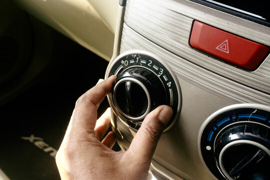 turning the air conditioner control knob on a car