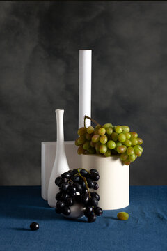 Still life with white vases, figures and grapes.