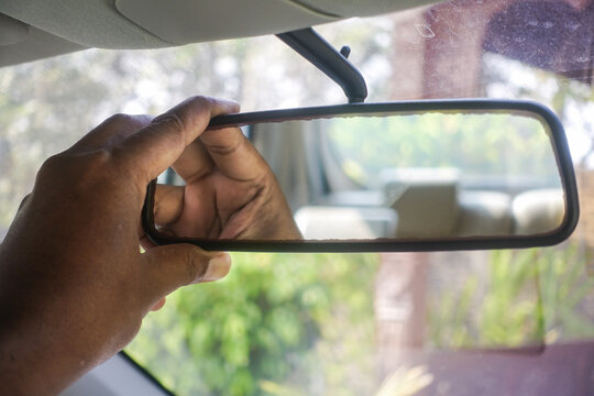 hand holding and operating the rear mirror
