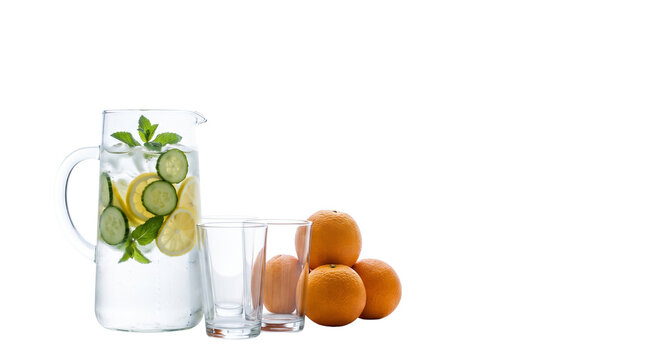 Refreshing detox water with cucumber lemon and mint in glass carafe, healthy citrus beverage with whole oranges and empty glasses isolated PNG with Transparent Background