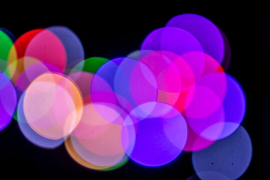 Deep blue and purple bokeh circles glow along the upper left corner against dark background.