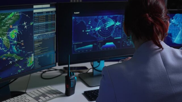 logistics operator using GPS radar and real-time fleet management dashboard on computer.