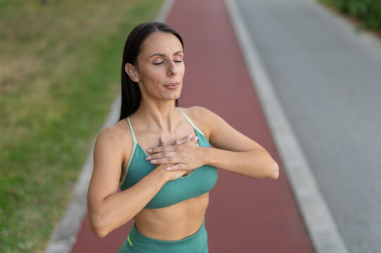 Woman practicing yoga breathing meditation outdoors