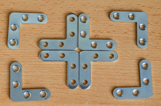 Arrangement of metal brackets on wooden surface