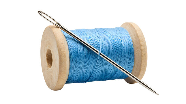 A wooden spool of light blue sewing thread with a silver metallic sewing needle lying diagonally across the center of the frame against a clean solid white studio background isolated composition