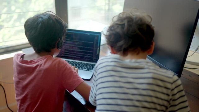 Young boys learning coding on a laptop computer, fostering early stem education and programming skills, showcasing the concept of child prodigies and future technology careers