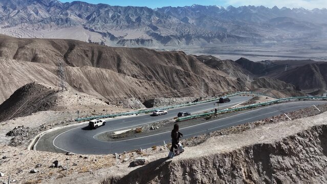winding panlong ancient road in xinjiang with cars driving on mountain highway