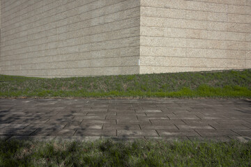 Grass and paved ground at the foot of a stone wall © zhu difeng