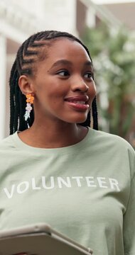 Volunteer, discussion or manager outdoor with tablet, task brief or schedule in charity project. Happy, black woman or NGO worker with tech, lead coordination or appointing duty in outreach program.